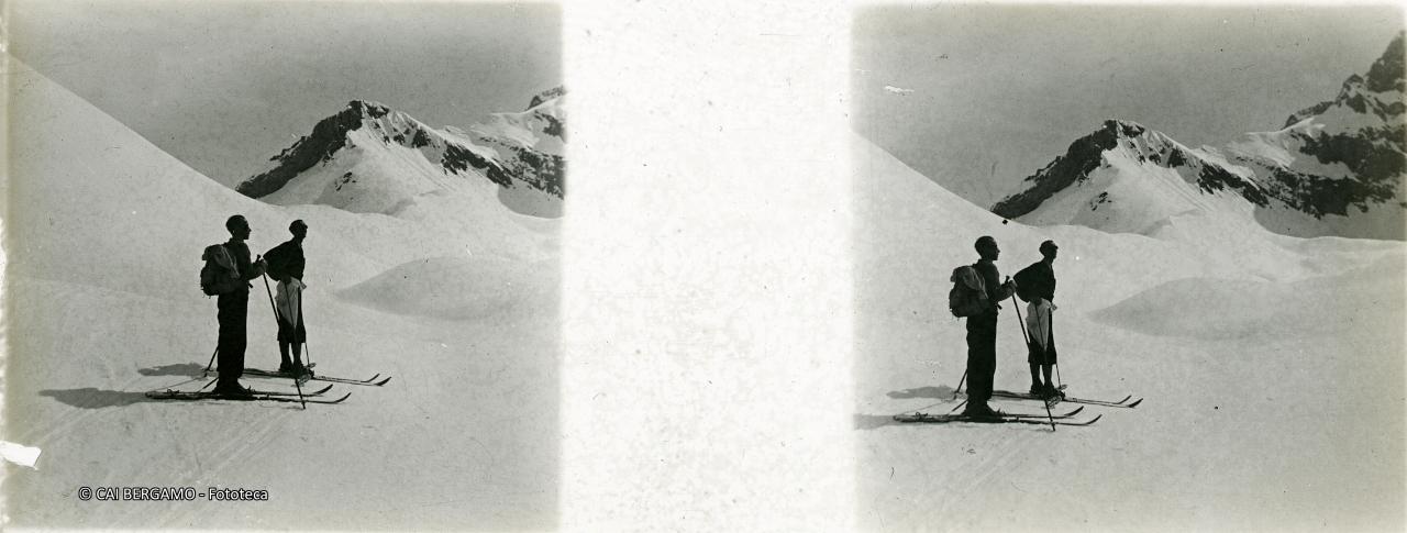 Scialpinisti al passo innevato con l'Arera sulla destra
