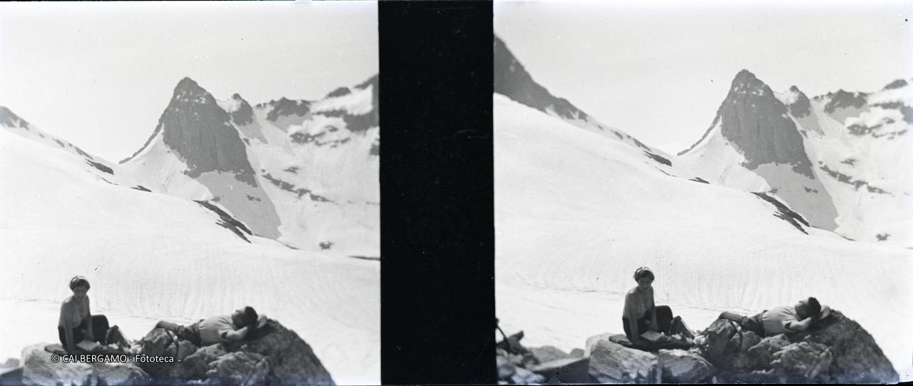 Tintarella per una coppia sotto il passo di  Valsecca innevato ed il pizzo Poris