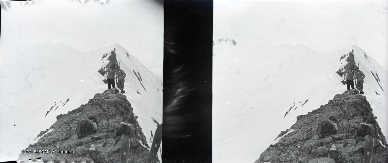 Foto ricordo lungo la cresta, con sci e zaini in primo piano