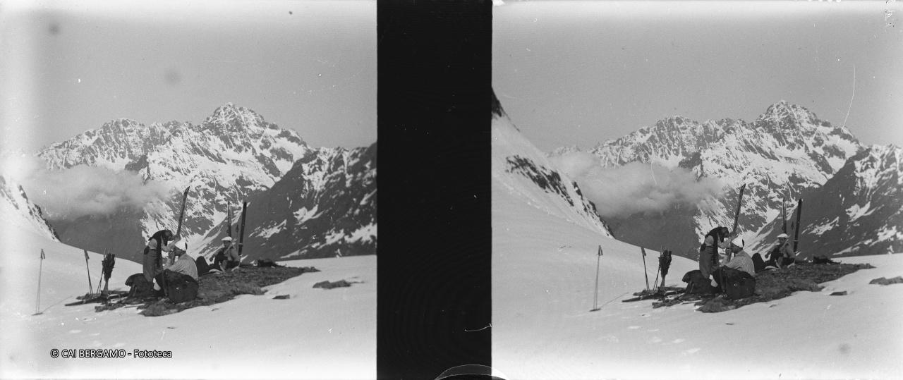 Pulizia degli sci prima della discesa  e sullo sfondo il gruppo del Coca (?)