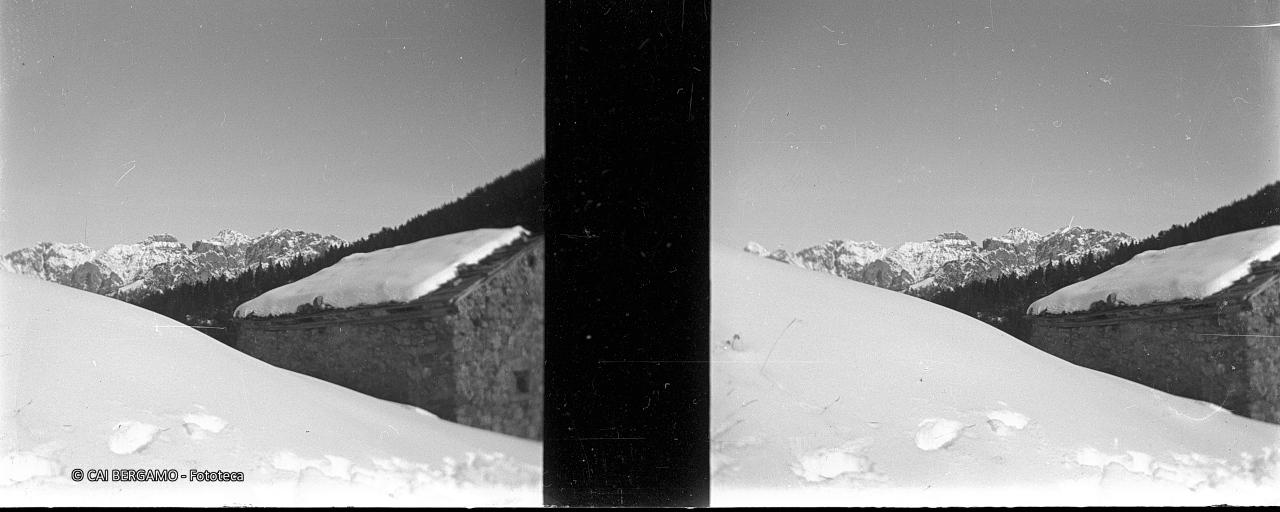 Baita nella versione invernale con scorcio sulle cime circostanti