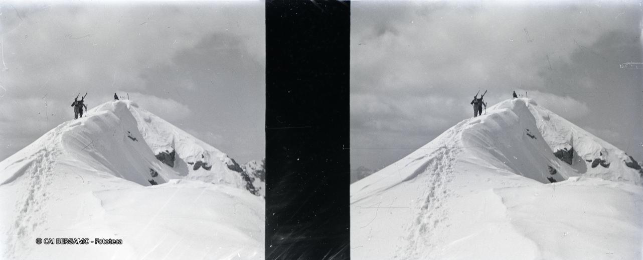 Concorrenti con gli sci a spalla sulla cima del Madonnino
