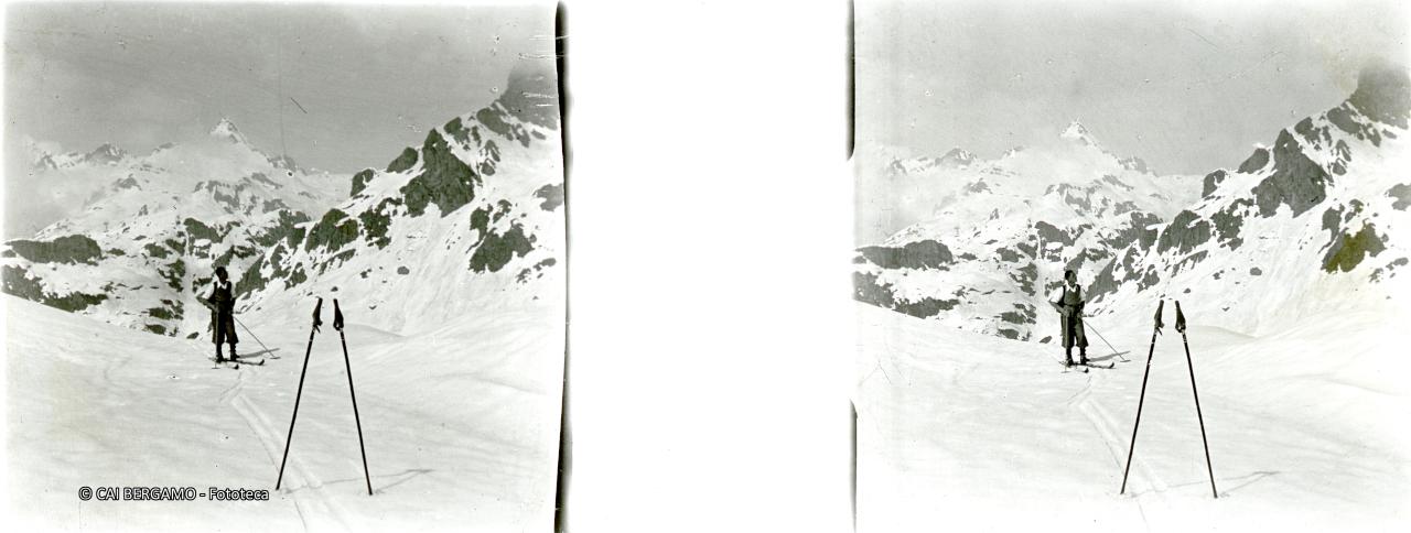 Scialpinista con racchette in primo piano