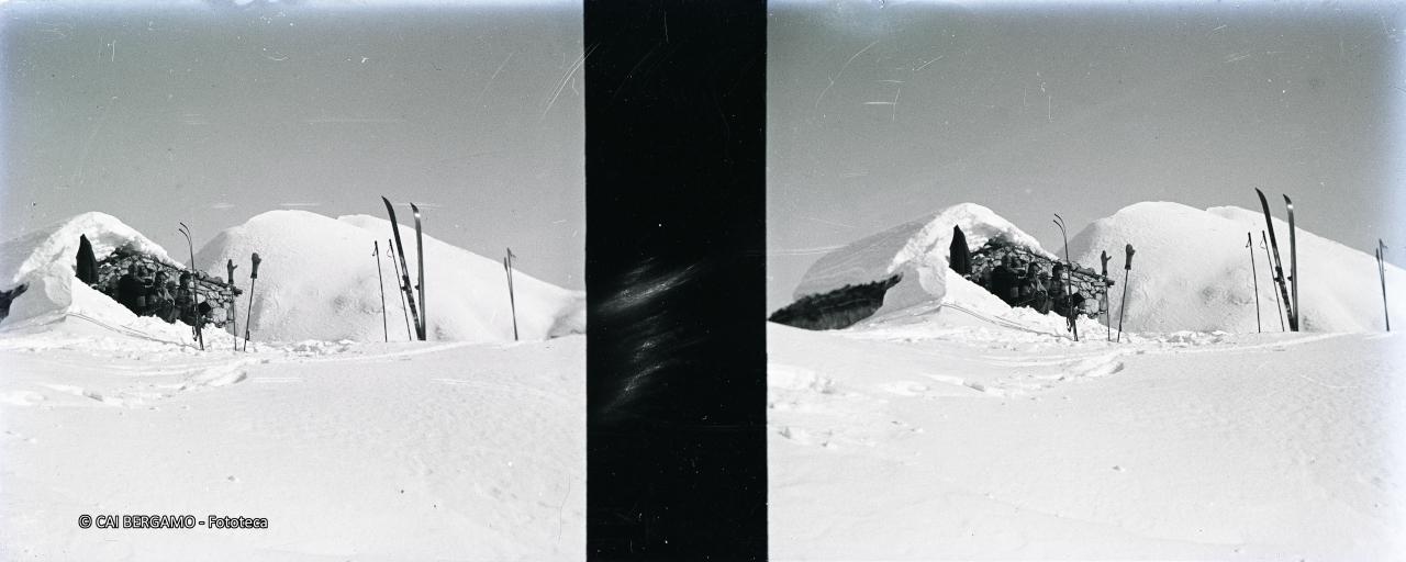 In sosta accanto a baita e sci al sole