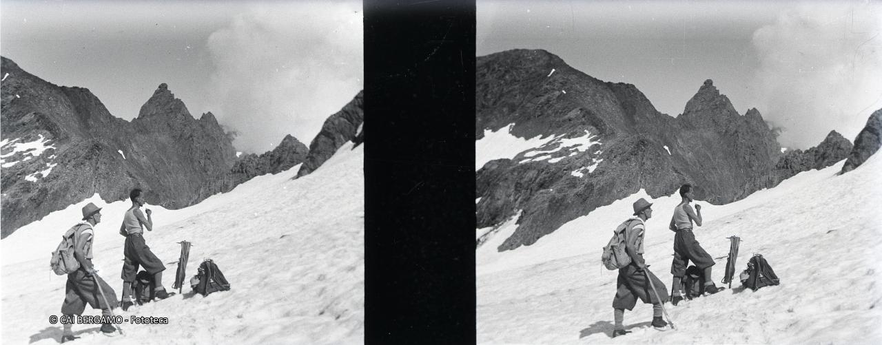 Escursionisti in maniche di camicia con zaino, piccozza e corda