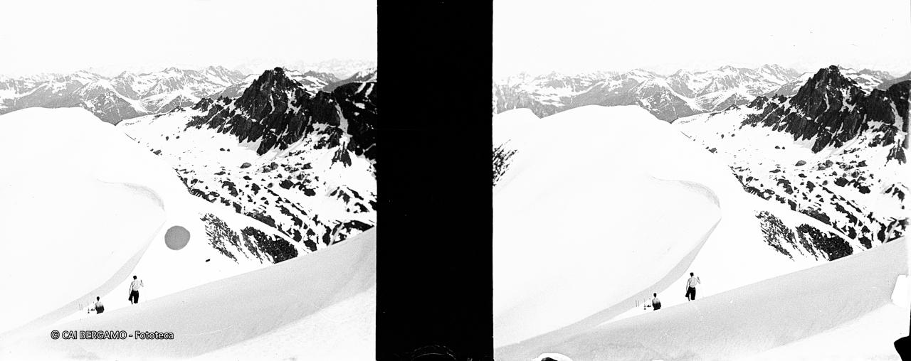 Pizzo Farno innevato con sciatori a piedi in discesa e monte Corte sulla destra