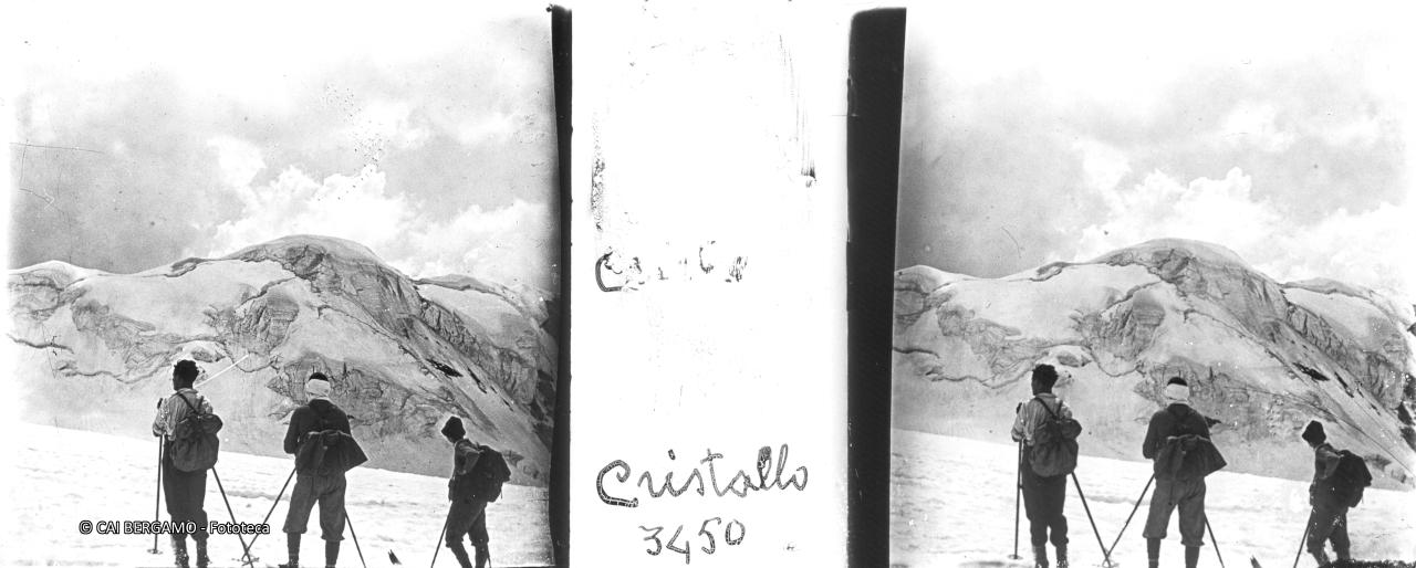 Sguardo sul Cristallo interamente coperto di neve e ghiaccio, con tre sciatori di spalle