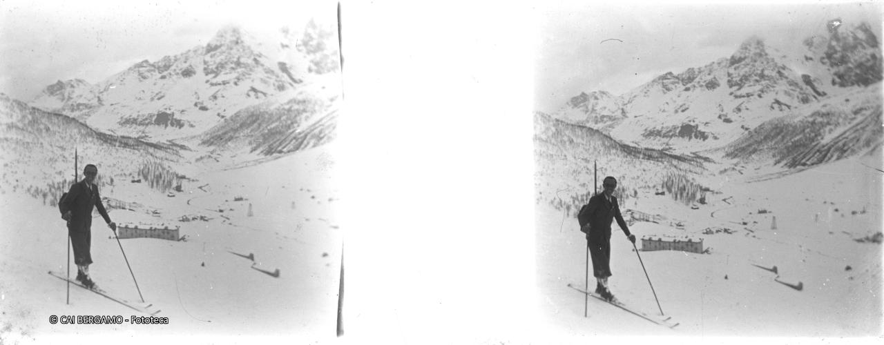 Sciatore con piccozza nello zaino con valle Valtournenche sottotante, libera dagli impianti di risalita