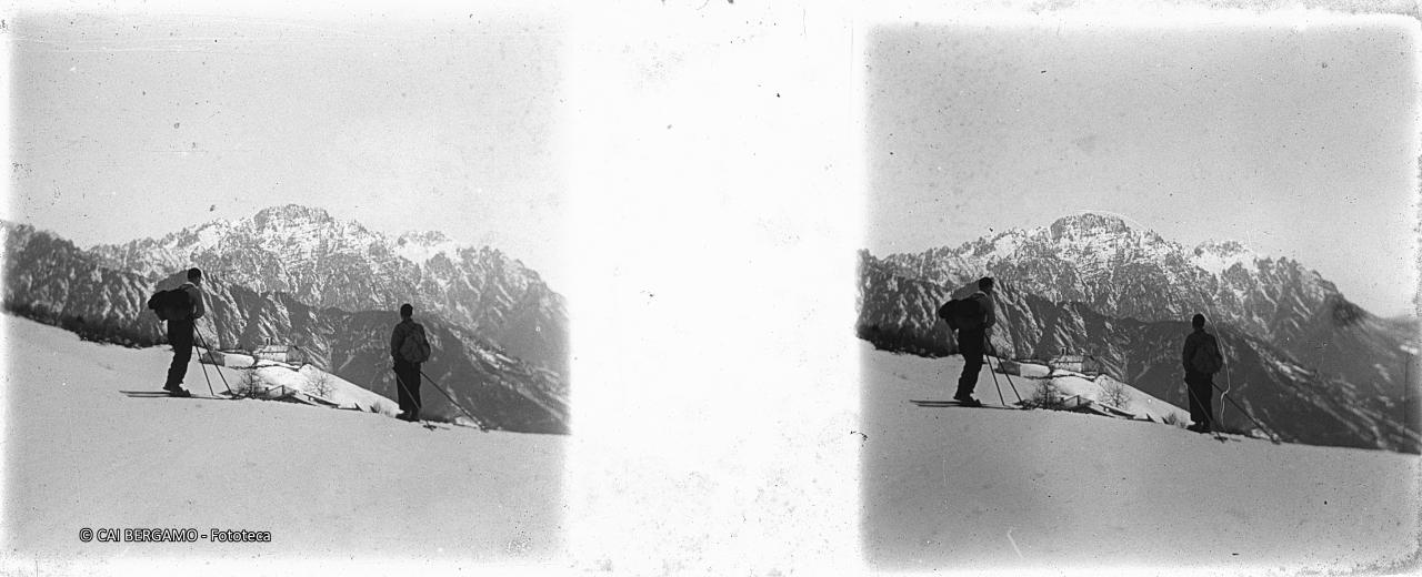 Sciatori con sguardo verso gruppetto di case e chiesina