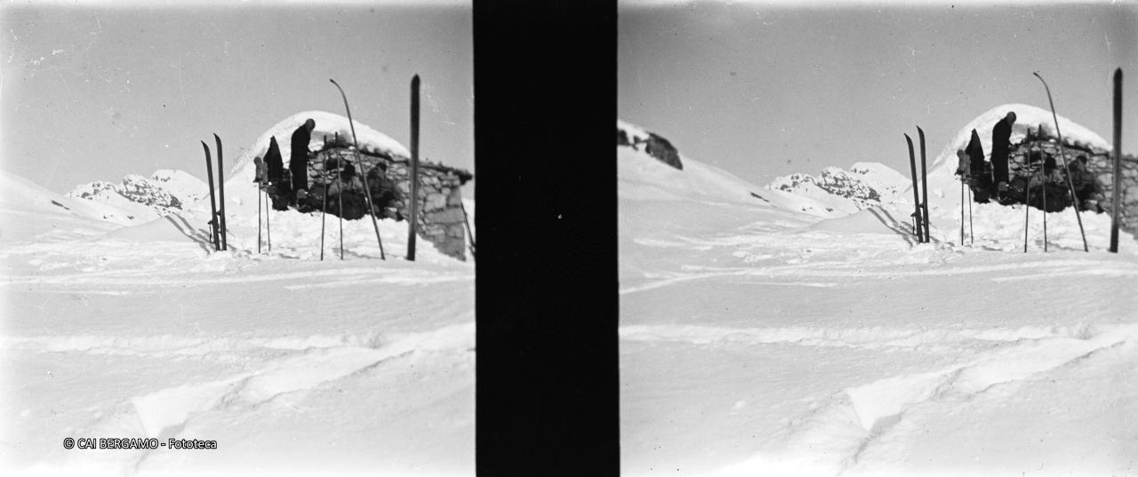 Fermata davanti a baita con ski e bastoncini disseminati