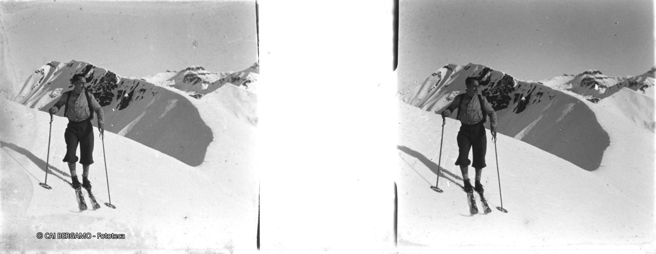 Skiatore in procinto di una bella discesa con la cima Benefit e passo Omini