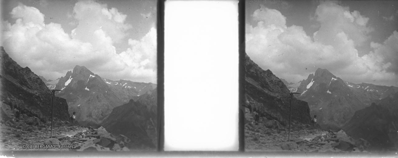 Pizzo Recastello dal sentiero della Valmorta, con piccozza in primo piano ed escursionista in lontananza