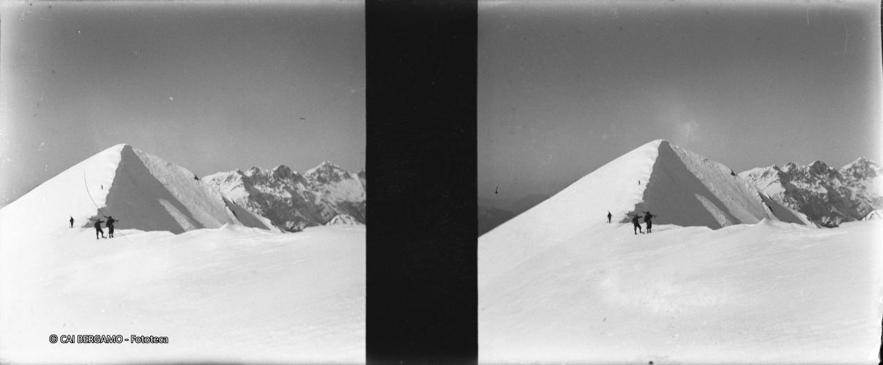 Ski a spalle con la retrostante cima Timogno ed il gruppo dell'Arera sullo sfondo