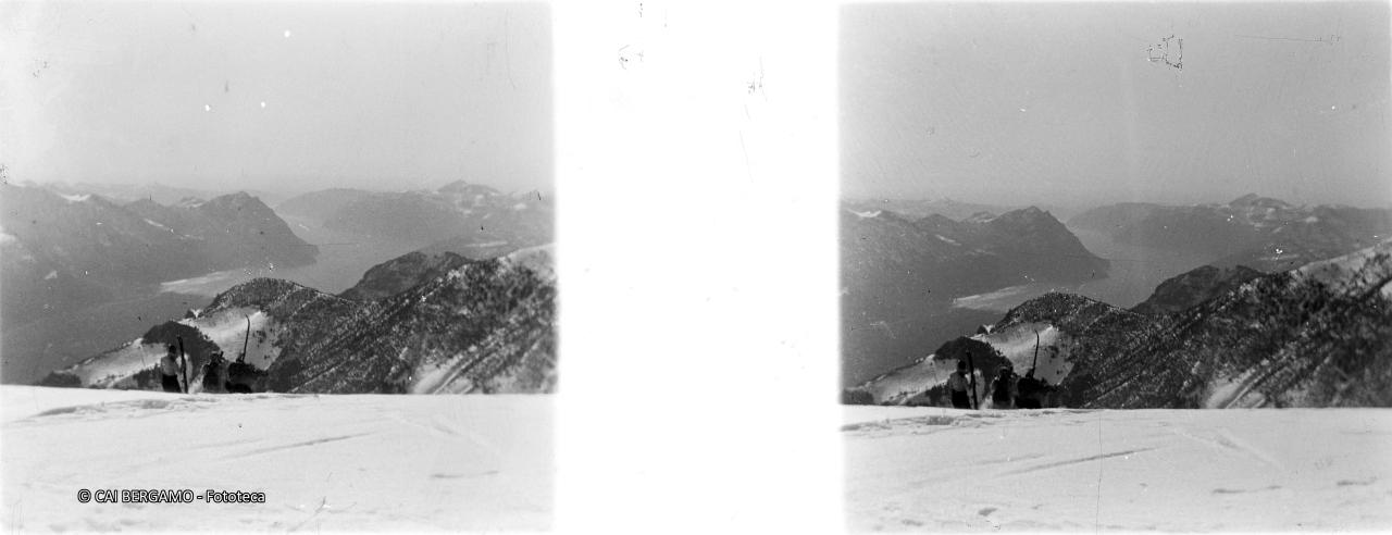 Vista sul lago d'Iseo con sciatori sotto il profilo nevoso