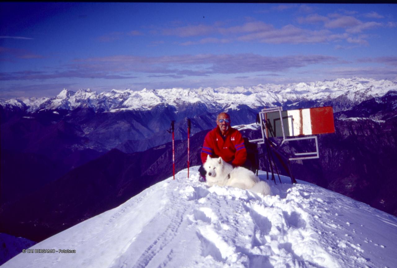 Foto ricordo di Pezzotta sulla cima, in lontananza le Alpi svizzere